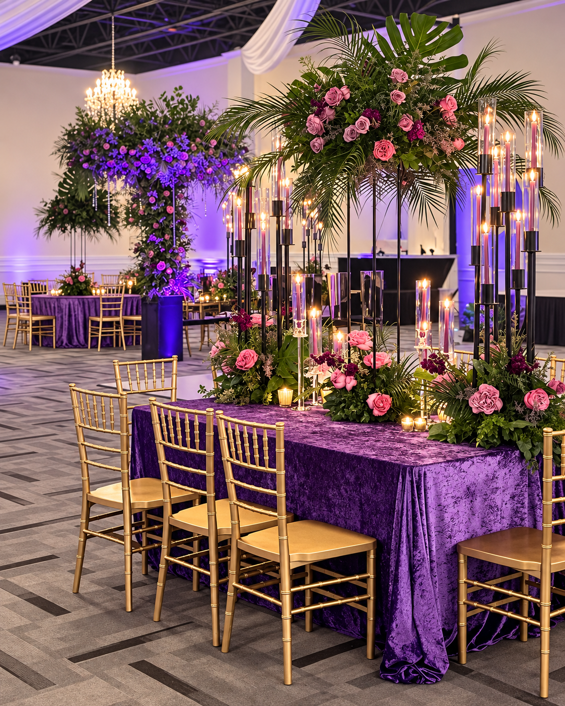 Purple velvet tablescape with tropical florals, pink roses, and a candlelit installation.